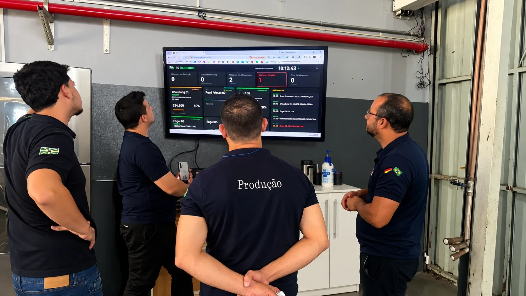 Equipe de produção do cliente acompanhando o painel de indicadores durante treinamento da A2M